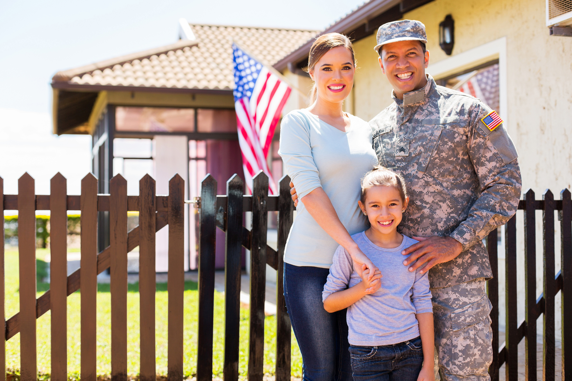 Military family in front of a new house